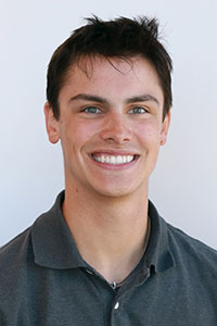 Man with dark hair wearing a grey collard shirt