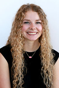 Woman with Long curly blonde hair wearing a black shirt