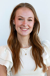 Woman with light brown hair wearing a white blouse