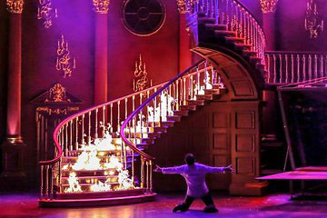 Theatre set. Ma performing net to a flaming staircase on stage 