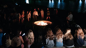 Group of student sitting around bonfire