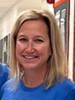 White woman blonde hair wearing a blue shirt smiling at camera