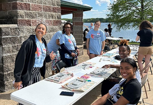 group of students sitting outside doing crafts